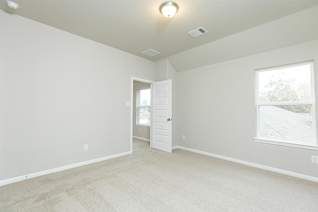 carpeted spare room with lofted ceiling