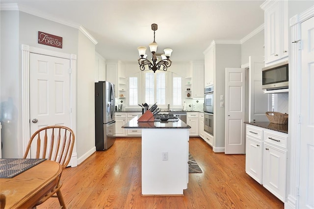 kitchen with a breakfast bar area, a center island, light wood-type flooring, stainless steel appliances, and white cabinets