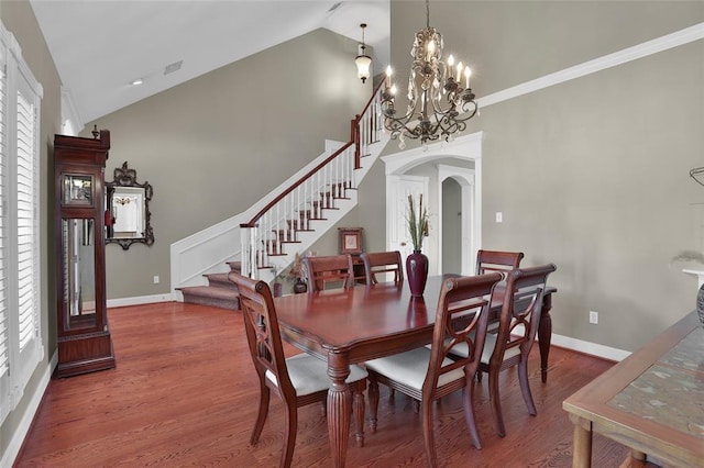 dining space featuring crown molding, hardwood / wood-style flooring, high vaulted ceiling, and a chandelier