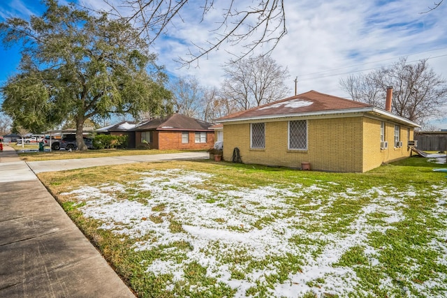 view of snow covered exterior with a yard