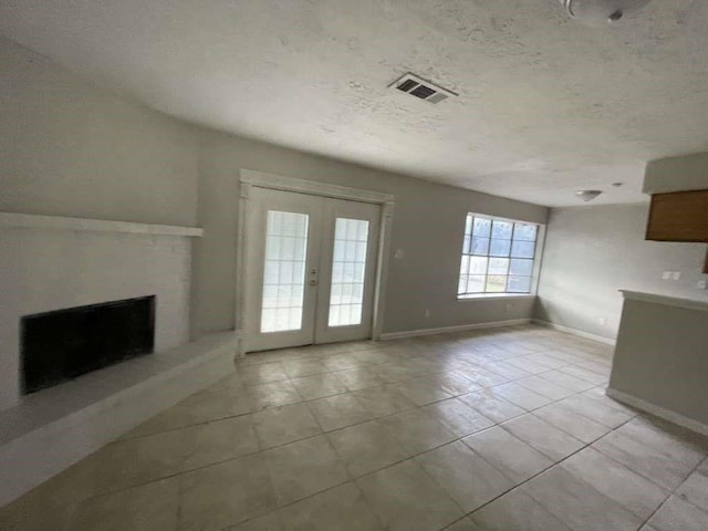 unfurnished living room featuring french doors and light tile patterned floors