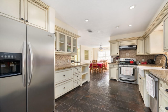 kitchen with tasteful backsplash, stainless steel appliances, sink, and cream cabinetry