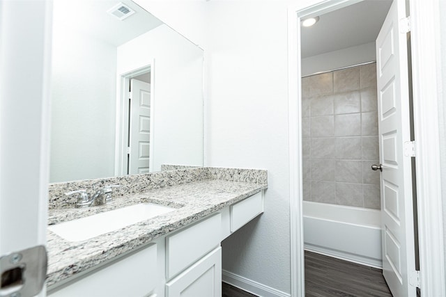 bathroom featuring vanity, hardwood / wood-style flooring, and tiled shower / bath