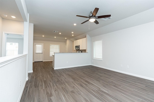 unfurnished living room featuring ceiling fan and dark hardwood / wood-style floors