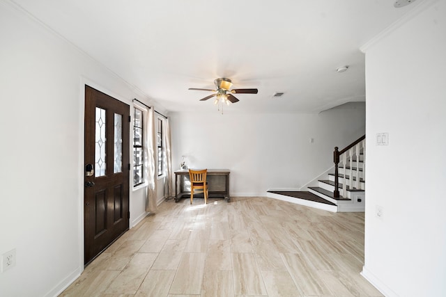 entrance foyer with ornamental molding and ceiling fan