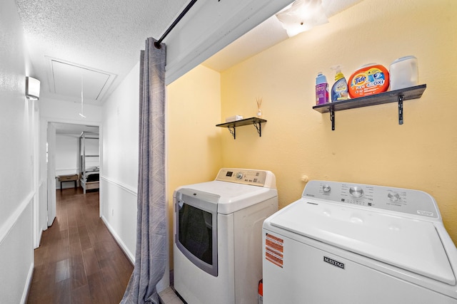 washroom featuring washing machine and dryer, dark hardwood / wood-style floors, and a textured ceiling