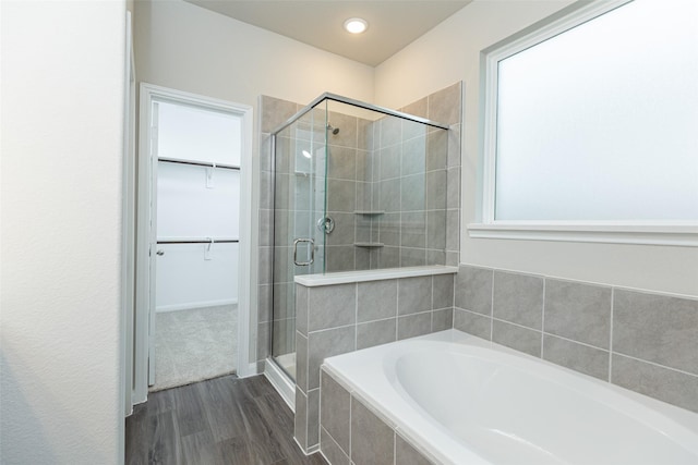 bathroom featuring hardwood / wood-style flooring and shower with separate bathtub