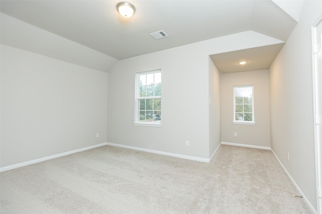 empty room featuring lofted ceiling and light colored carpet