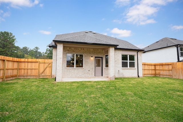 back of house with a yard and a patio