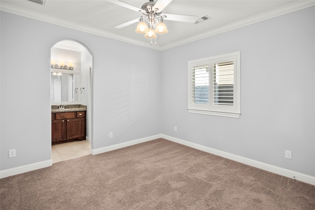 carpeted spare room featuring crown molding, ceiling fan, and sink