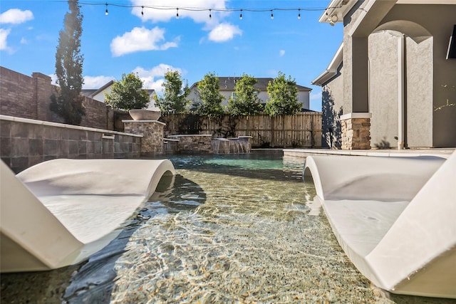 view of yard featuring a fenced in pool and pool water feature