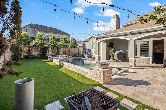 view of yard with a swimming pool with hot tub, a fire pit, and a patio