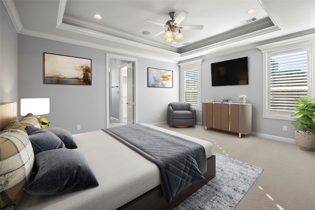 carpeted bedroom featuring ceiling fan, ornamental molding, and a raised ceiling