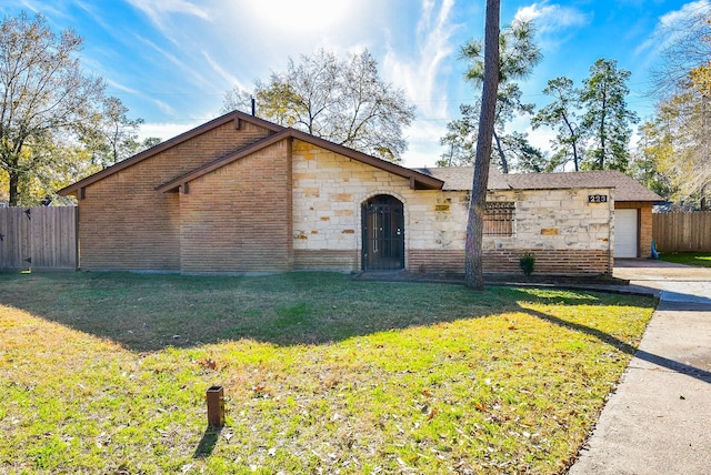 single story home with a garage and a front yard