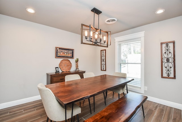 dining area featuring dark wood-type flooring and a chandelier