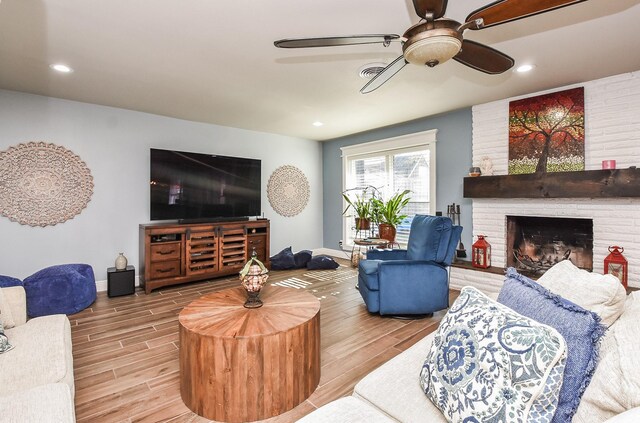 living room featuring ceiling fan and a fireplace