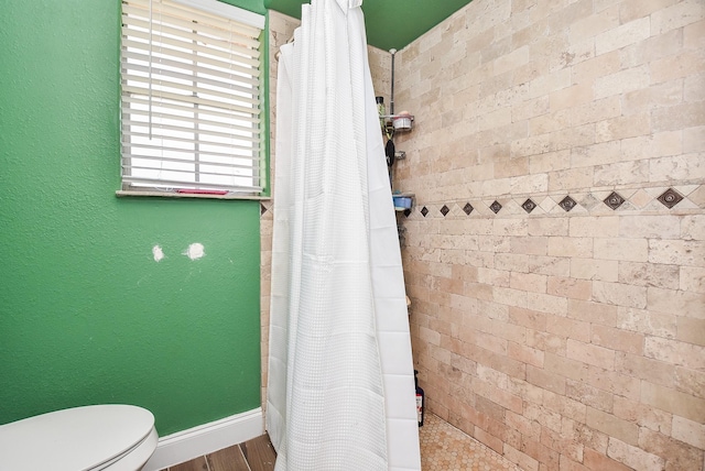 bathroom with a shower with curtain and toilet