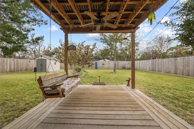 wooden terrace with a storage shed and a yard