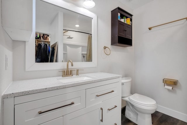 bathroom featuring vanity, wood-type flooring, and toilet