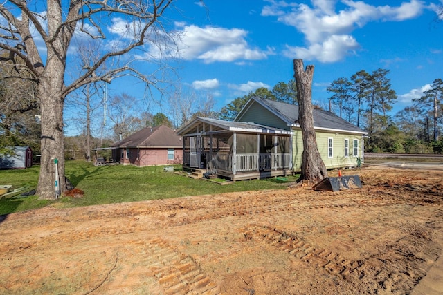 back of house featuring a sunroom and a yard