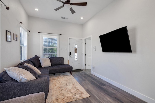 living room featuring ceiling fan, a towering ceiling, and dark hardwood / wood-style flooring