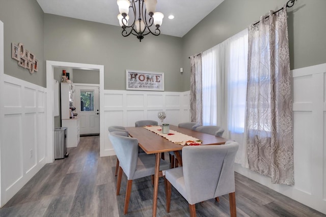 dining space featuring wood-type flooring and a notable chandelier