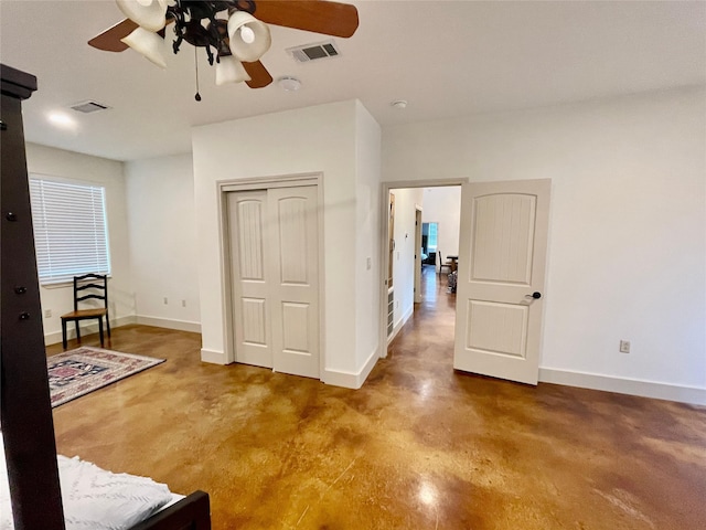 spare room with ceiling fan and concrete flooring