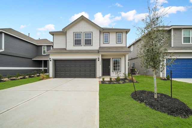 view of front of home featuring an attached garage, driveway, and a front yard