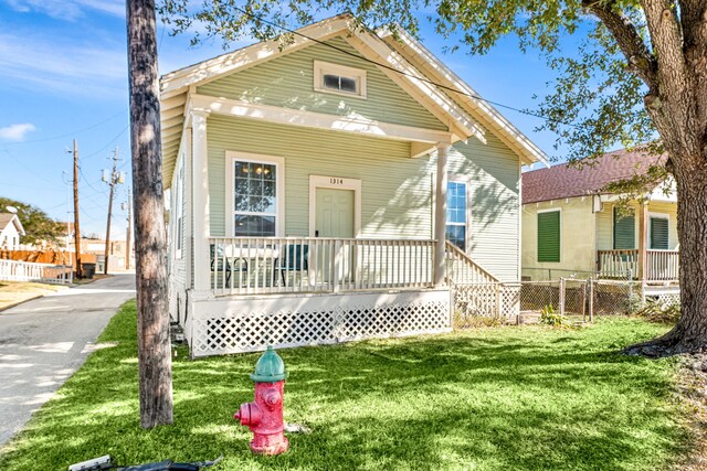 view of front of house featuring covered porch and a front lawn