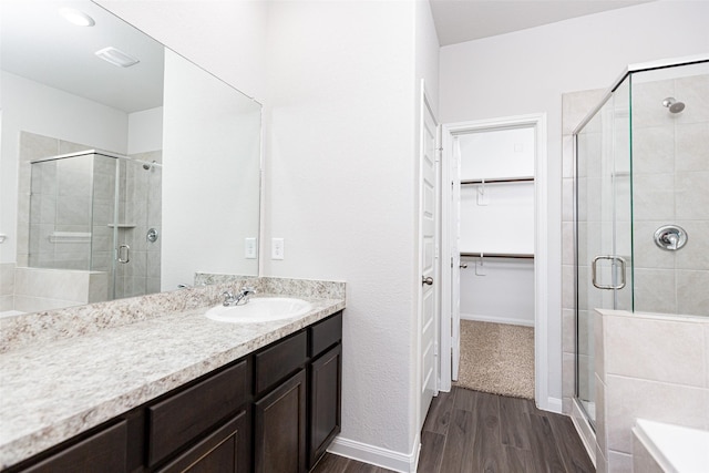 bathroom with vanity, wood-type flooring, and a shower with door