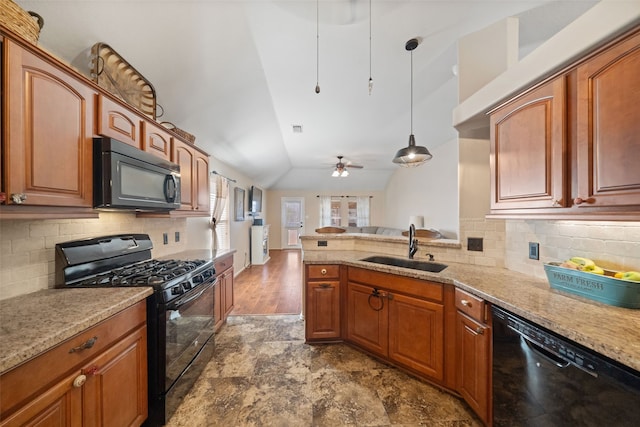 kitchen with sink, vaulted ceiling, pendant lighting, light stone countertops, and black appliances