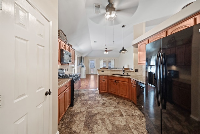 kitchen featuring lofted ceiling, sink, hanging light fixtures, kitchen peninsula, and black appliances