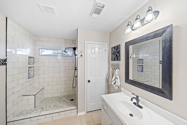 bathroom featuring vanity, tile patterned floors, and tiled shower