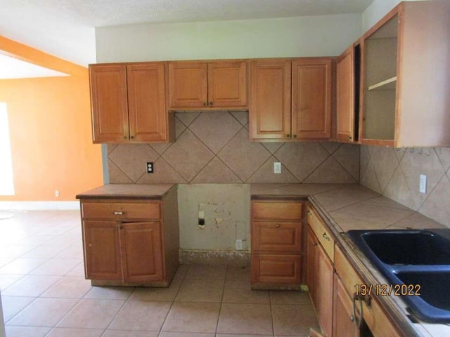 kitchen with sink, decorative backsplash, and light tile patterned flooring