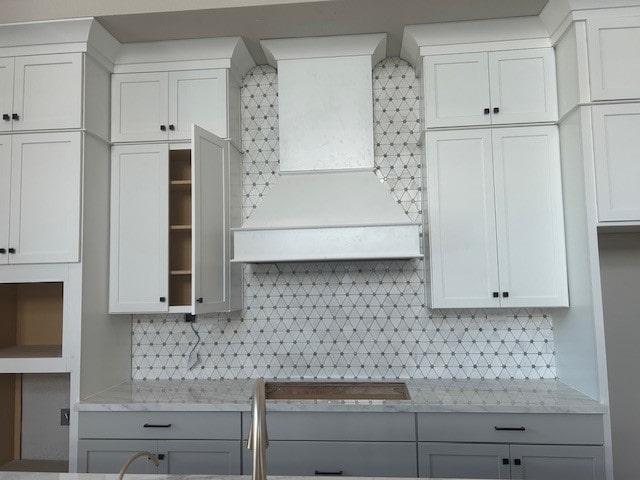 4423 Southpoint Way, Fulshear, TX 77441 - kitchen featuring premium range hood, backsplash, white cabinets, open shelves, and light stone counters