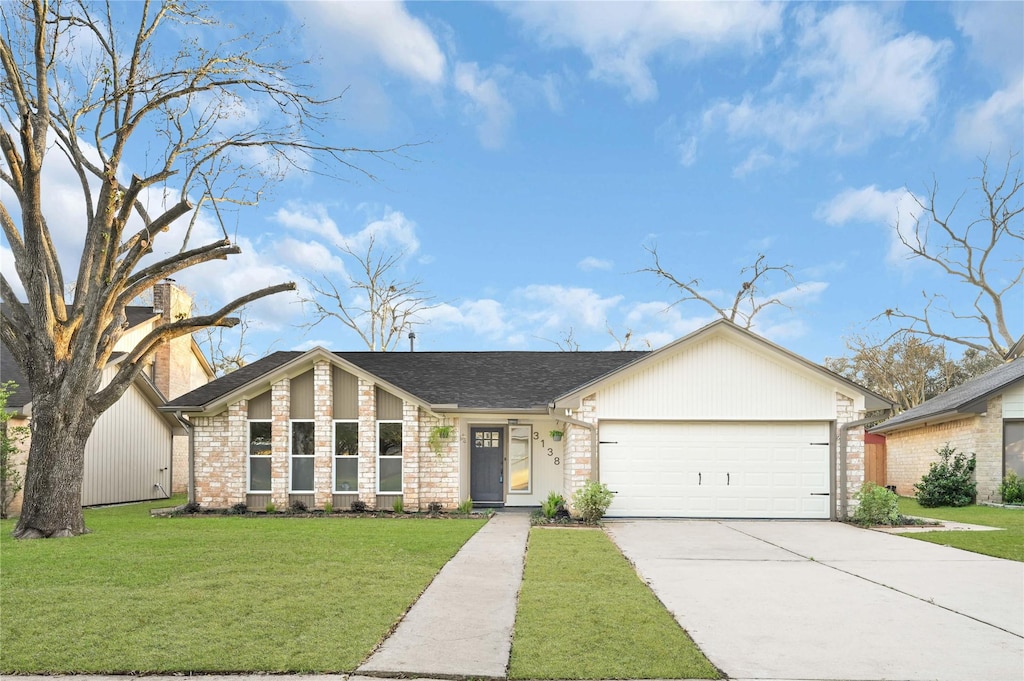 ranch-style home with a garage and a front lawn