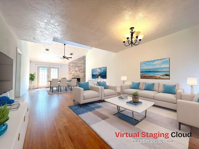 living room with lofted ceiling, hardwood / wood-style flooring, ceiling fan with notable chandelier, and a textured ceiling