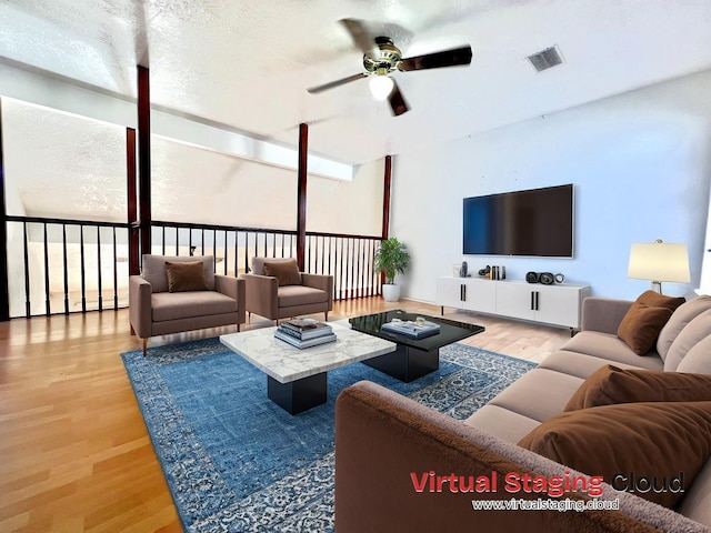 living room with hardwood / wood-style flooring, ceiling fan, and a textured ceiling