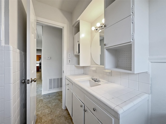 bathroom with vanity and decorative backsplash