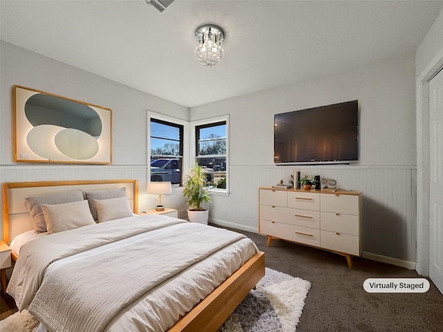 bedroom featuring dark colored carpet and an inviting chandelier