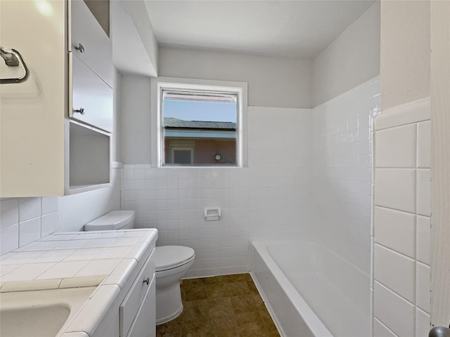 bathroom with vanity, toilet, and tile walls