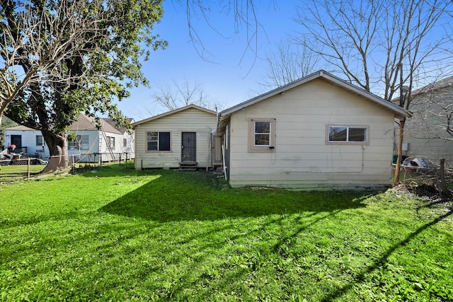 rear view of house featuring a yard