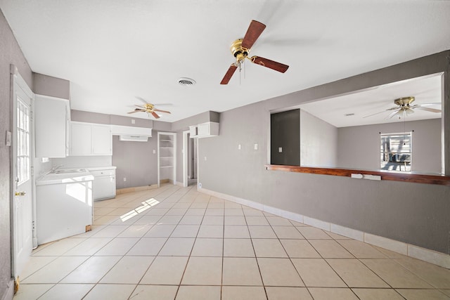 interior space featuring light tile patterned flooring, ceiling fan, and sink