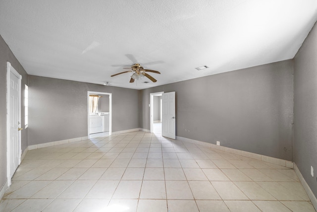 tiled empty room featuring a textured ceiling, washer / dryer, and ceiling fan