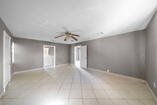 128 Kress St, Houston, TX 77020 - spare room with a ceiling fan, a textured ceiling, light tile patterned flooring, washer / clothes dryer, and baseboards