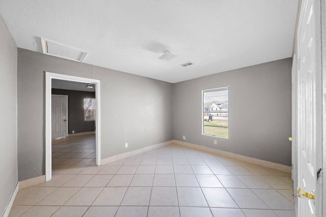 tiled spare room with a textured ceiling