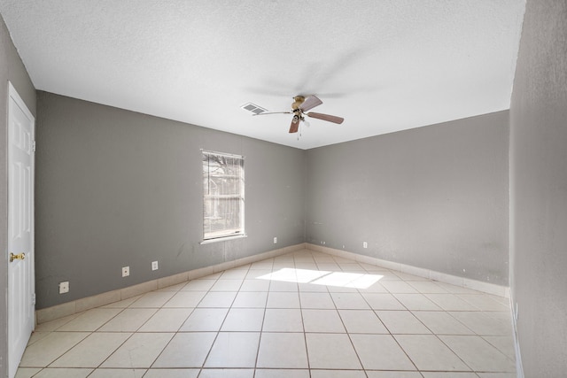 unfurnished room with ceiling fan, a textured ceiling, and light tile patterned floors