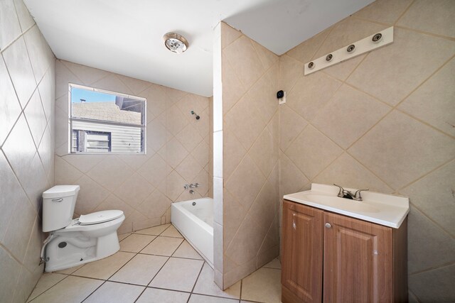 full bathroom with tile patterned floors, vanity, toilet, and tile walls