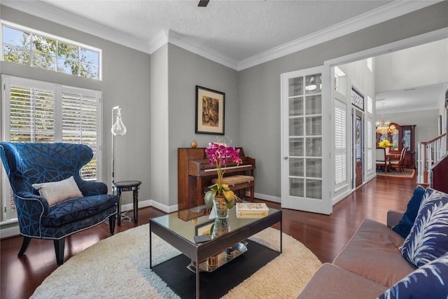 living room featuring ornamental molding, dark hardwood / wood-style flooring, a chandelier, and a textured ceiling