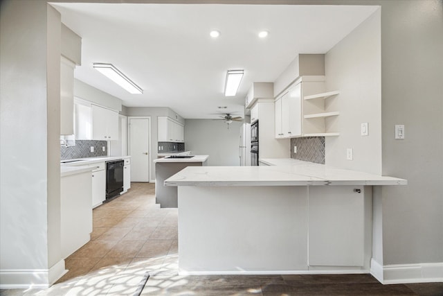 kitchen with tasteful backsplash, kitchen peninsula, white cabinets, ceiling fan, and black appliances